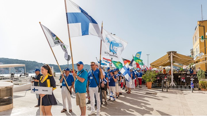 Skupina ljudi drži razne nacionalne zastave na događaju na otvorenom