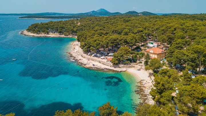 Aerial view of a beach surrounded by lush greenery on the island of Losinj