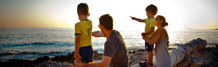 A family watching the sunset by the sea