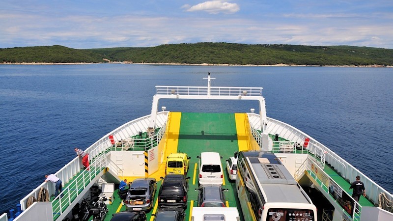 A ferry carrying vehicles on the sea near the islands of Cres and Losinj